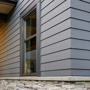 house with gray vinyl siding and stone facade